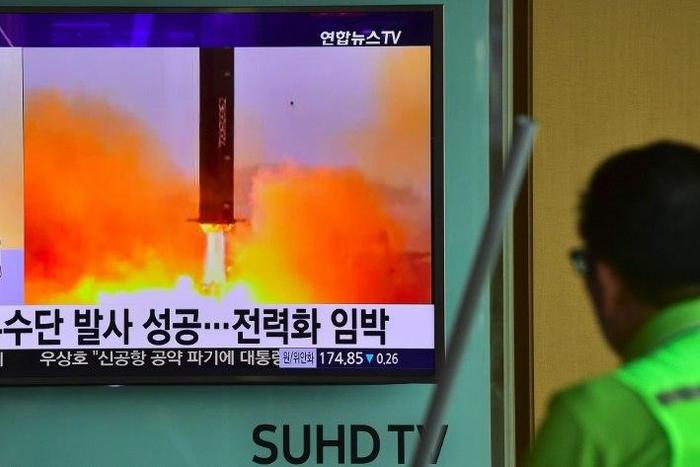 A man walks past a television screen reporting news of North Korea's Musudan missile test in June 2016