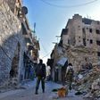 Syrian pro-government forces walk past rubble in old Aleppo's Jdeideh neighbourhood on December 9, 2016