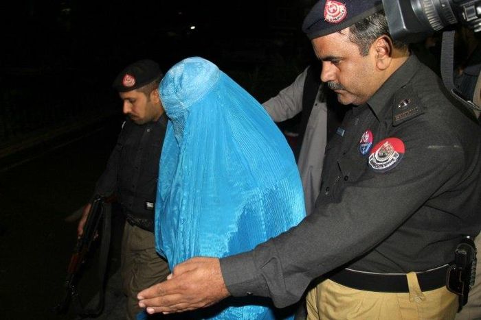 Pakistani policemen escort Afghan refugee woman Sharbat Gula (C) as she leaves the Lady Reading Hospital where she was treated, in Peshawar on November 9, 2016, before her deportation to Afghanistan