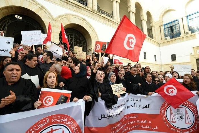 Tunisian lawyers shout anti-government slogans during a demonstration against a draft 2017 budget that would impose a public sector pay freeze on December 6, 2016 outside Tunis law court