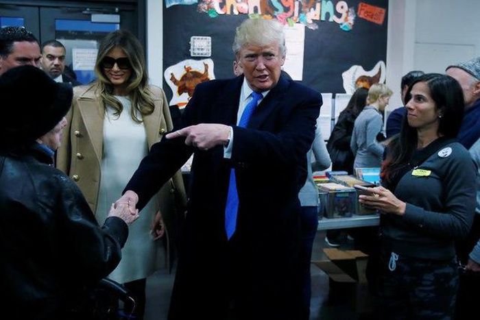 Republican presidential nominee Donald Trump shakes hands with a woman before voting at PS 59 in New York, New York, U.S. November 8, 2016