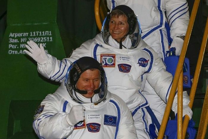 Members of the main crew of the expedition to the International Space Station, Russia's cosmonaut Oleg Novitsky (L) and US astronaut Peggy Whitson wave as they walk to board the rocket at the Russian-leased Baikonur cosmodrome in Baikonur