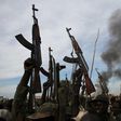 Rebel fighters hold up their rifles as they walk in front of a bushfire in a rebel-controlled territory in Upper Nile State, South Sudan February 13, 2014.