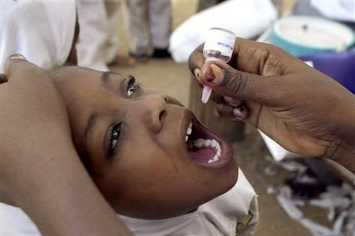 A health worker gives a child an oral polio vaccine in Kano, Nigeria.