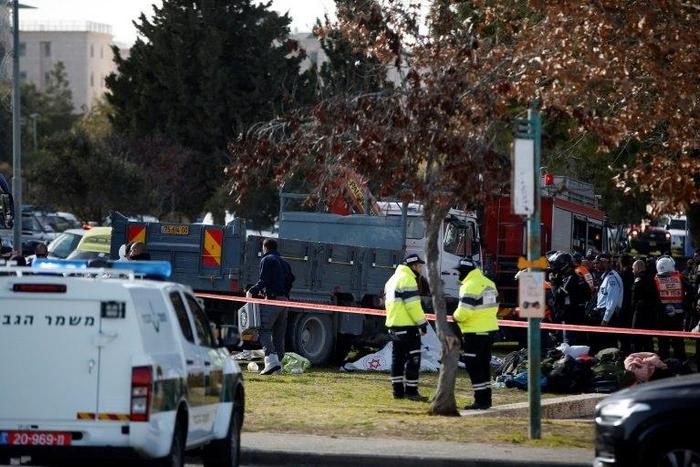 Israeli security forces and medics gather next to a flatbed truck at the site of a ramming attack in Jerusalem, on January 8, 2017