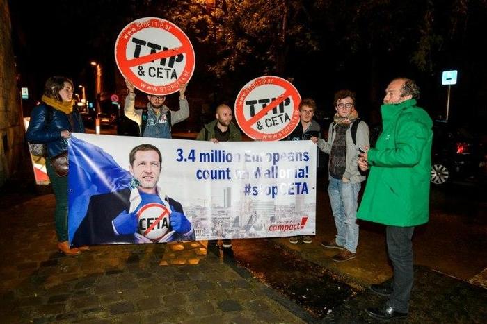 Protesters hold up a placard reading '3,4 million Europeans count on Wallonia - stop CETA' during a demonstration in as a meeting in Namur, on October 18, 2016