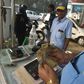 An Indian customer pays for fuel with old 500 rupee notes at a petrol station in New Delhi on the last day on which the old currency can be used to purchase fuel