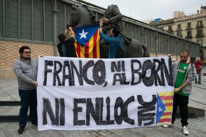 Protestors hang a Catalan Pro-independence flag on a headless sculpture of Francisco Franco riding a horse during the unveiling of the statue