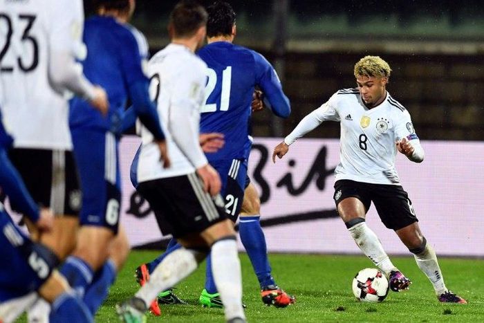 Germany's midfielder Serge Gnabry (R) runs with the ball during their World Cup 2018 qualifying football match on November 11, 2016 at the San Marino stadium in Serravalle