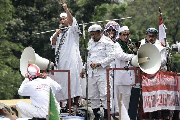 Muslim leaders broadcast their message as they march past Jakarta's governor's office on November 4.