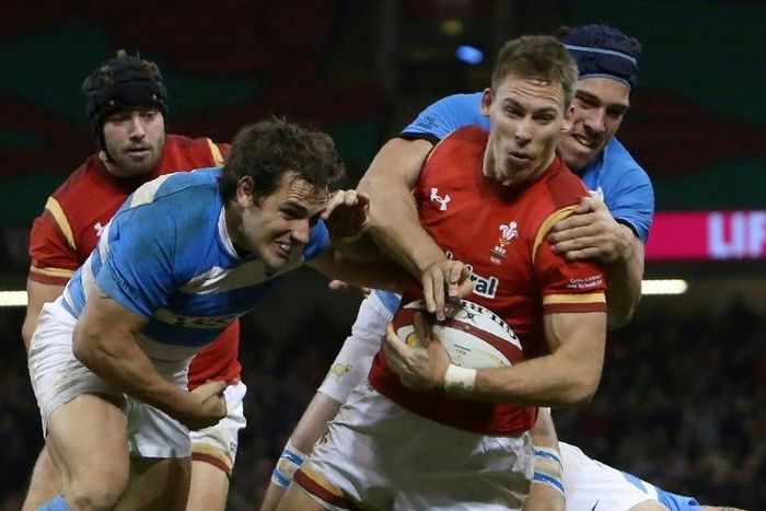 Wales' wing Liam Williams (2nd right) takes two Argentina players with him on his way to scoring the first Wales try during their rugby union test match in Cardiff on November 12, 2016