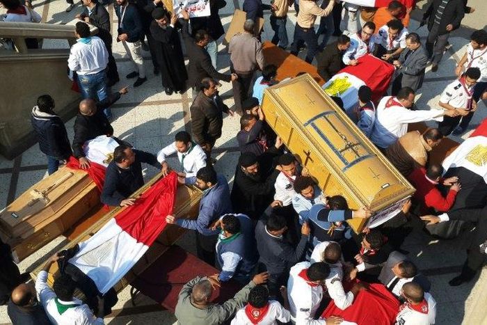 Egyptian clergymen and officials carry the coffins of the victims of a church bombing in Cairo, on December 12, 2016