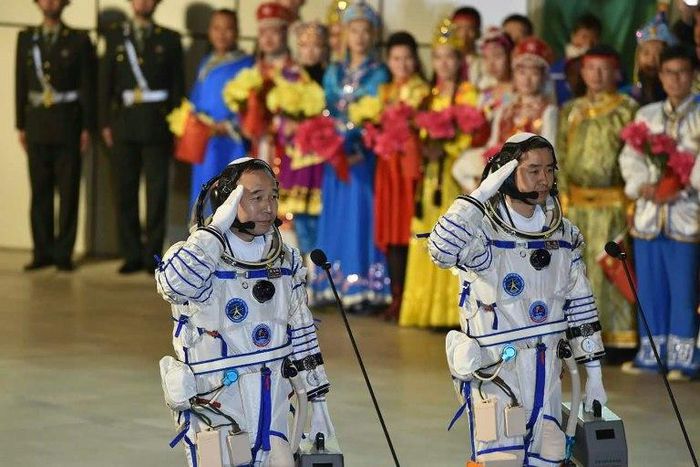 Chinese astronauts Jing Haipeng (L) and Chen Dong salute during the send-off ceremony of the Shenzhou-11 manned space mission, at the Jiuquan Satellite Launch Center in north-western Gansu Province, on October 17, 2016