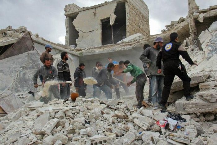 Rescuers and civilians inspect a destroyed building in the Syrian village of Kfar Jales, on the outskirts of Idlib, following air strikes by Syrian and Russian warplanes on November 16, 2016