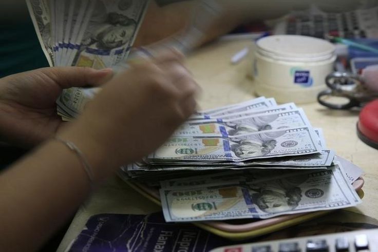 A worker counts U.S. 100-dollar banknotes inside a money changer in Manila, Philippines March 23, 2016.    REUTERS/Romeo Ranoco