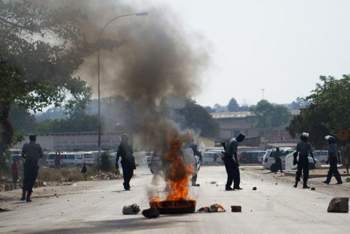 Demonstrators from the Zimbabwean pressure group Tajamuka protest next to a burning tyre in Makokoba Township, Bulawayo