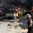 Vehicles of pro-government fighters burn after an IS group suicide bomber detonated explosives nearby on August 16, 2016 