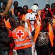 A migrant, who is part of a group intercepted aboard a dinghy off the coast in the Mediterranean sea, is helped by a member of Spanish Red Cross after arriving on a rescue boat at a port in Malaga, southern Spain, June 9, 2016.