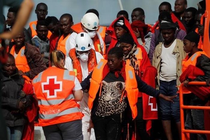 A migrant, who is part of a group intercepted aboard a dinghy off the coast in the Mediterranean sea, is helped by a member of Spanish Red Cross after arriving on a rescue boat at a port in Malaga, southern Spain, June 9, 2016.