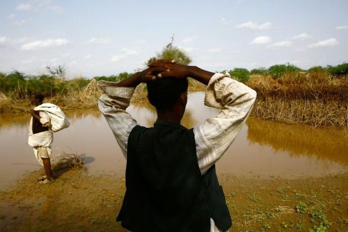 A Sudanese man looks at the river Gash that burst its banks flooding the village of Makli on August 14, 2016, destroying thousands of houses and submerging several villages 