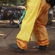 A member of the French Red Cross disinfects the area around a motionless person suspected of carrying the Ebola virus as a crowd gathers in Forecariah January 30, 2015.