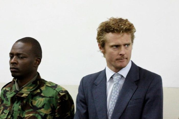 British national Jack Marrian (R), flanked by a police officer, appears in court in Nairobi on August 8, 2016, where he faces charges of trafficking 100 kilos of cocaine from Brazil to Mombasa 