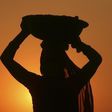 A woman labourer carrying cement is silhouetted against the setting sun at the site of a commercial complex on the outskirts of Jammu November 22, 2012.