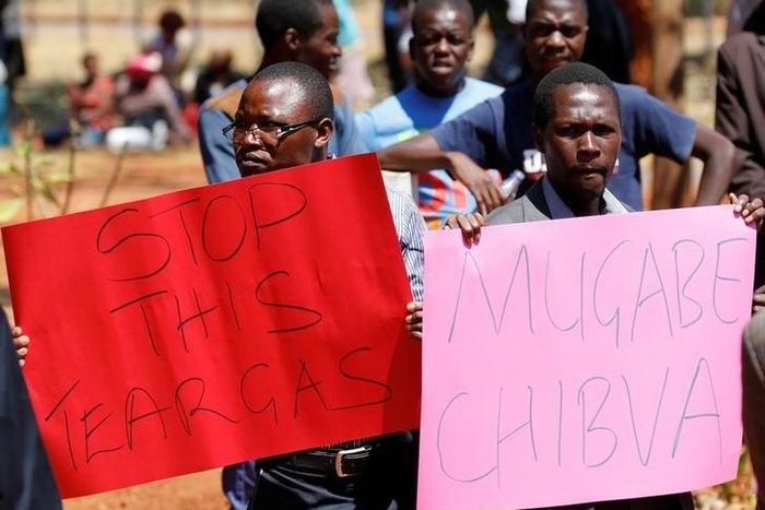 Opposition party supporters hold placards during a court appearance of those arrested following Friday's protest march, in Harare, Zimbabwe, August 29, 2016.