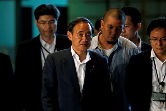 Japan's Chief Cabinet Secretary Yoshihide Suga (C) arrives at Prime Minister Shinzo Abe's official residence in Tokyo, Japan, July 2, 2016, following news of an attack on a restaurant in the Bangladeshi capital by gunmen. 