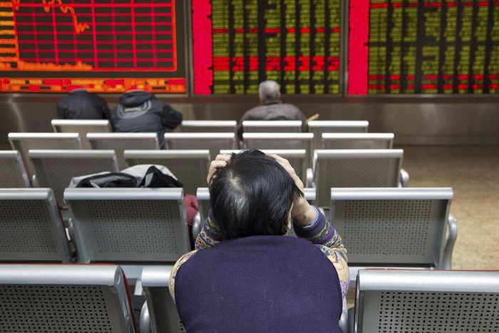An investor sits in front of an electronic board showing stock information at a brokerage house in Beijing, China, November 30, 2015. REUTERS/Li Sanxian