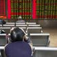 An investor sits in front of an electronic board showing stock information at a brokerage house in Beijing, China, November 30, 2015. REUTERS/Li Sanxian