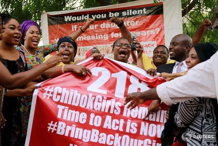 Members of the #BringBackOurGirls (#BBOG) campaign react on the presentation of a banner which shows "218", instead of the previous "219", referring to kidnapped Chibok school girls, during a sit-out in Abuja, Nigeria May 18, 2016, after receiving news...