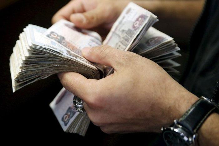 A customer counts his Egyptian 50 pound notes at an exchange office in downtown Cairo, Egypt, April 19, 2016. REUTERS/Amr Abdallah Dalsh