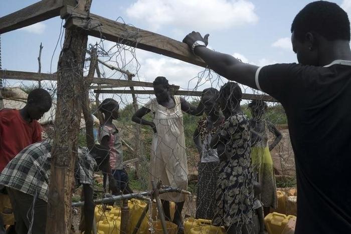 South Sudanese women collect water in the United Nations protection of civilians site hosting about 30,000 people displaced during the recent fighting in Juba, South Sudan, July 22, 2016.