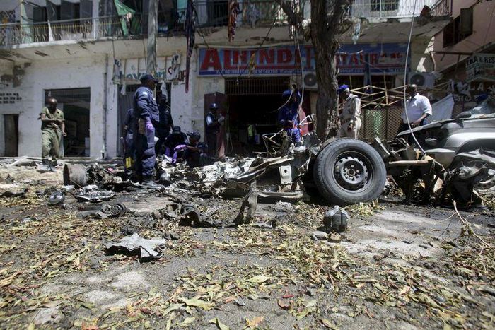 Somali soldiers and explosion experts assess the wreckage of a car destroyed in a bomb explosion at a local government headquarters that killed five people in Somalia's capital Mogadishu, April 11, 2016. REUTERS/Ismail Taxta