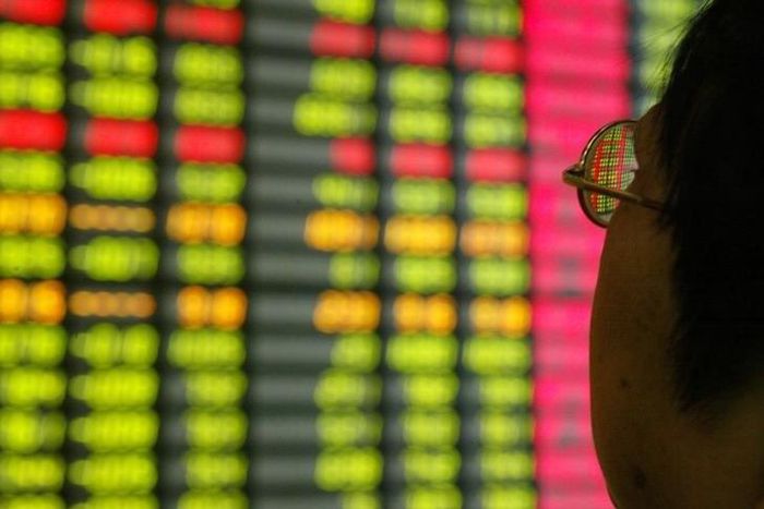 A Chinese investor monitors share prices at a securities company in Shanghai, file.