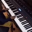 Olamide teaches son how to play the Piano