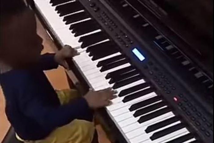 Olamide teaches son how to play the Piano
