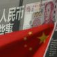China's national flag is seen in front of a poster explaining the design of new 100 yuan banknote at a branch of a commercial bank at a business district in Beijing, China, January 21, 2016.