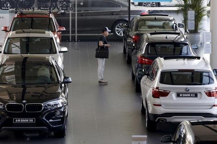 A man takes a look at BMW cars at a dealer shop in Beijing, China, September 11, 2015.    REUTERS/Kim Kyung-Hoon