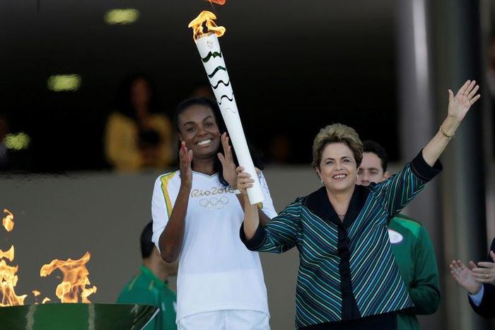 Brazil's President Dilma Rousseff (R) waves after lighting a cauldron with the Olympic Flame next to Fabiana Claudino, captain of the Brazilian volleyball team, during the Olympic Flame torch relay at Planalto Palace in Brasilia, Brazil, May 3, 2016. R...