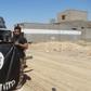 Iraqi security forces stand with an Islamic State flag which they pulled down in the town of Hit in Anbar province, April 2, 2016.