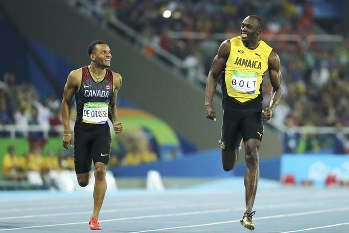 Usain Bolt (JAM) of Jamaica and Andre De Grasse (CAN) of Canada compete.  REUTERS/Lucy Nicholson