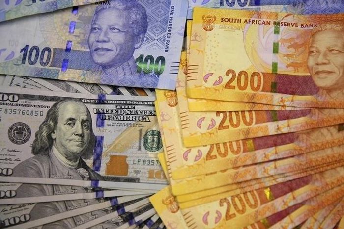 South African bank notes featuring images of former South African President Nelson Mandela (R) are displayed next to the American dollar notes in this photo illustration in Johannesburg August 13 2014.   REUTERS/Siphiwe Sibeko