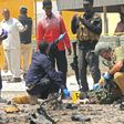A foreign security officer checks a body at the scene of a suicide attack in Mogadishu, on July 31, 2016 