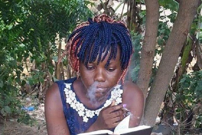 This lady is reading the Holy Bible while smoking at the same time