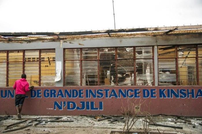 A man looks at a burned courthouse in Kinshasa following two days of clashes between police and protesters demanding President Joseph Kabila resign
