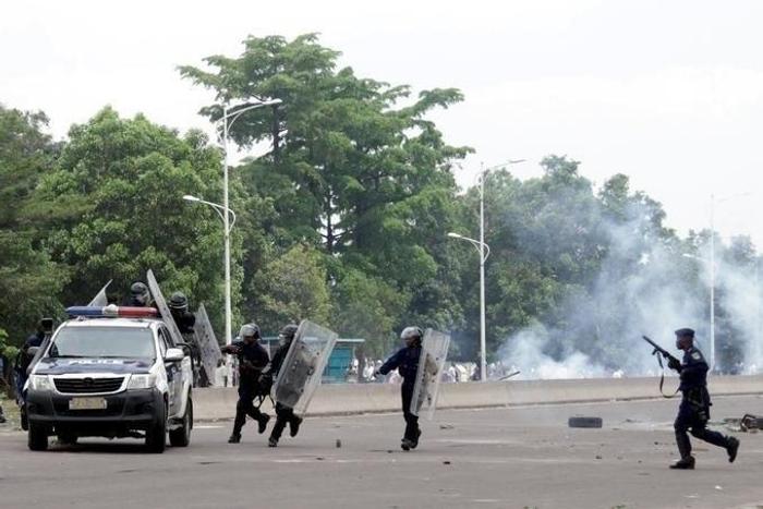 Congolese policemen run to their vehicle during a clash with opposition activists participating in a march to press President Joseph Kabila to step down in the Democratic Republic of Congo's capital Kinshasa, September 19, 2016.