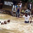 Some men are seen trying to navigate the flood.