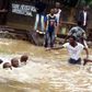 Some men are seen trying to navigate the flood.